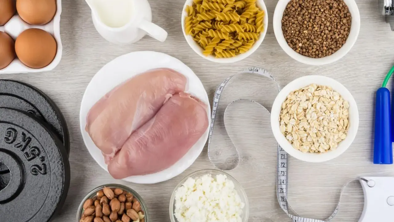 Składniki na dietę na masę mięśniową: kurczak, jajka, mleko, płatki owsiane, makaron, kasza gryczana, orzeszki ziemne, twaróg, hantle i skakanka.