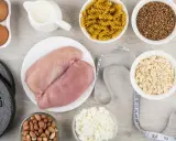 Składniki na dietę na masę mięśniową: kurczak, jajka, mleko, płatki owsiane, makaron, kasza gryczana, orzeszki ziemne, twaróg, hantle i skakanka.