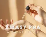 Delikatna aplikacja serum z kwasami PHA na dłoń. Skóra dłoni jest gładka, a kropla serum lśni w świetle.