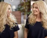 Dwie blondynki w granatowych bluzkach rozmawiają ze sobą.