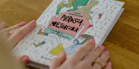Książka "Pierwsza miesiączka" z ilustracjami dziewczynek, która odpowiada na pytanie, w jakim wieku dziewczynki dostają okres.