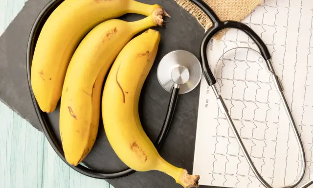 Trzy banany i stetoskop na tle EKG. Czy zastanawiałeś się, ile białka ma banan?